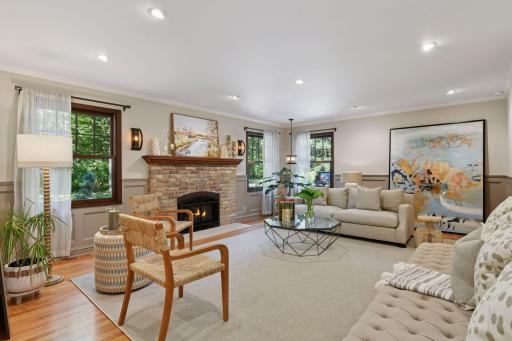 Stylish and sunlit, the front living room combines recessed lighting, generous windows, and a gas fireplace to create a warm, inviting atmosphere