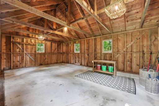 Versatile barn space featuring high vaulted ceilings, concrete floors, and complete electrical service for endless possibilities