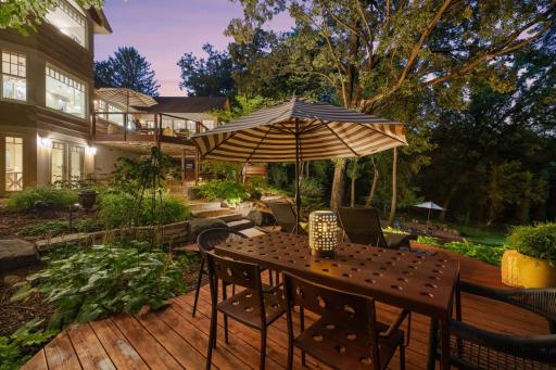 Twilight transforms the circular deck into a serene retreat, with soft lighting highlighting the dining area and casting a warm glow across the home's exterior