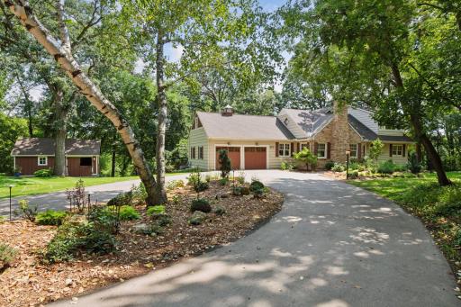 Graceful curved driveway leads to a beautifully landscaped front entrance, offering a welcoming and polished first impression