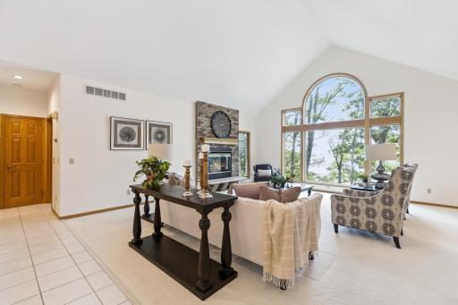 As you enter the home you are greeted by vaulted ceilings and floor to ceiling picture windows looking out over the lake from the main floor living room.