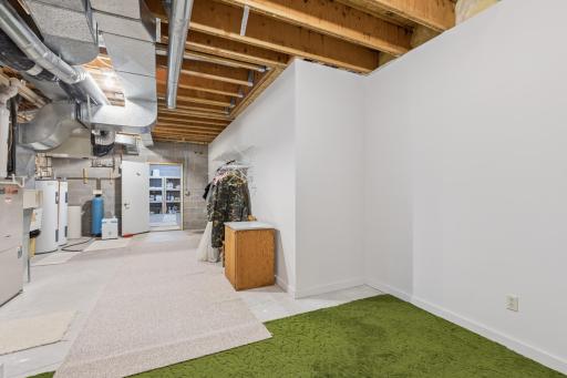 View of the mechanical room with lots of storage space. The is home features zoned HVAC and dual water heaters.