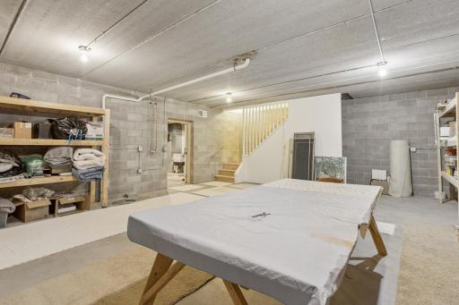 Just past the mechanical room is a workshop space complete with floor drain that is underneath the attached garage with stairs leading up to the garage. This is a perfect hobby room or just great additional storage space.