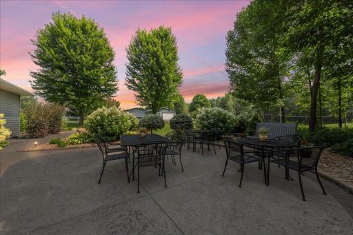 Outside, the home is surrounded by beautifully landscaped gardens and multiple spaces to enjoy the outdoors, including an expansive covered front porch, a large deck, a spacious patio, and a charming swing set nestled in the yard.