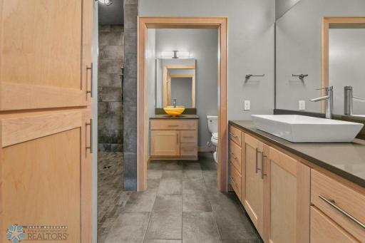 Master Bath features a tiled, curbless walk-in shower with grab bars & bench seat.