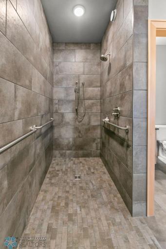 Master Bath's walk-in shower. Fully tiled & curbless with grab bars & bench seat.