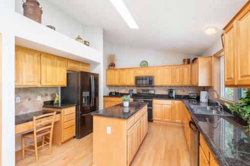 Center Island Kitchen with walk-in pantry, granite countertops & vaulted ceiling.