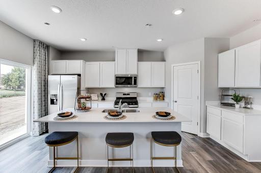 Townhome living just got an upgrade with the large island, spacious walk-in pantry and tons of cabinets. *Model home- colors and finishes will vary.