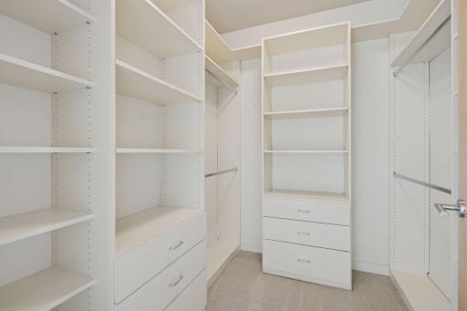 The walk-in closet in the primary suite is thoughtfully designed with adjustable custom shelving, creating a tailored space to keep everything organized in style.