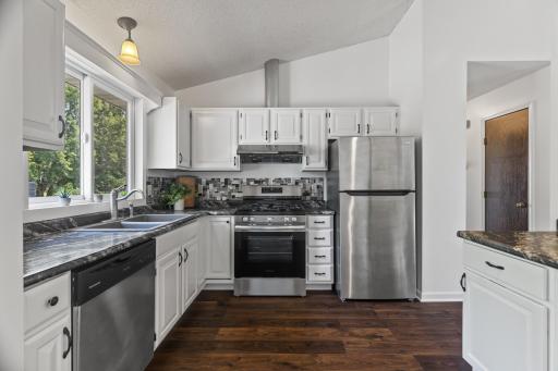 Crisp, White Cabinets, A Glass Tile Backsplash & Stainless Steel Appliances
