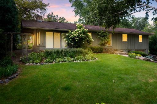 Tucked away on over half an acre of lush, private land, this beautifully maintained rambler is a hidden gem surrounded by mature trees, vibrant gardens, and a stunning array of flowering plants.