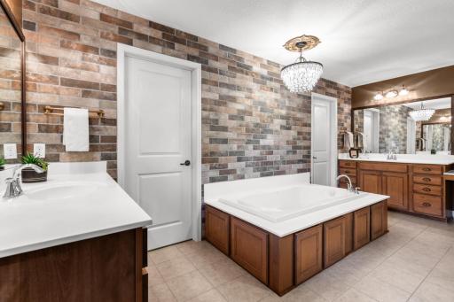 Ensuite includes a soaking tub, walk-in shower, and upgraded finishes for a peaceful retreat.