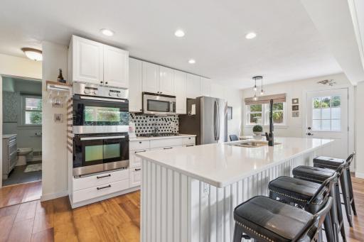 Fancy kitchen with quartz counter tops, large island with sink and dishwasher..jpeg