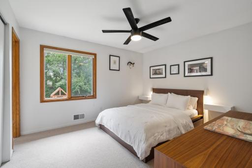 Main level primary bedroom with window overlooking the backyard.