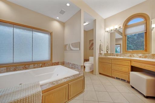 Large primary bathroom with heated tile flooring and double sinks - great soaker tub.