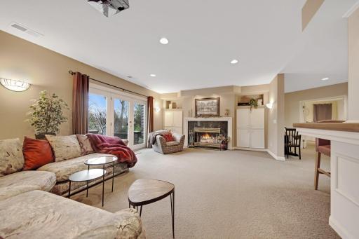 Lower level wood fireplace and surround sound stereo system in the cabinet to right of fireplace