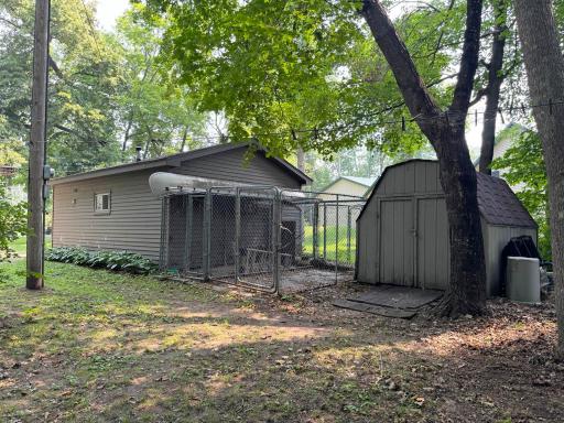 Views of the bunkhouse's exterior with dog kennels and the shed in the backyard.