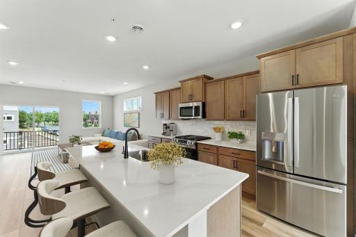 The sun filled kitchen has timeless finishes that blend an elevated feel with functionality. Beautiful quartz countertops and subway tile backsplash are accented by upgraded stainless appliances.