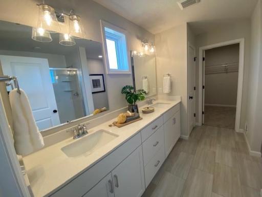 Double sinks, linen closet & large walk-in closet and large shower. Photos taken from model of similar floor plan. Photos may not depict actual home plan configuration. Features/materials/finishes shown contain options that are not included in price.