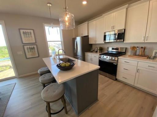 Lovely kitchen island breakfast bar. This is a to-be-built home still time to personalize: Spacious 3-car garage. This 5 bedroom home includes a Finished Lower Level. Photos taken from model of similar floor plan.