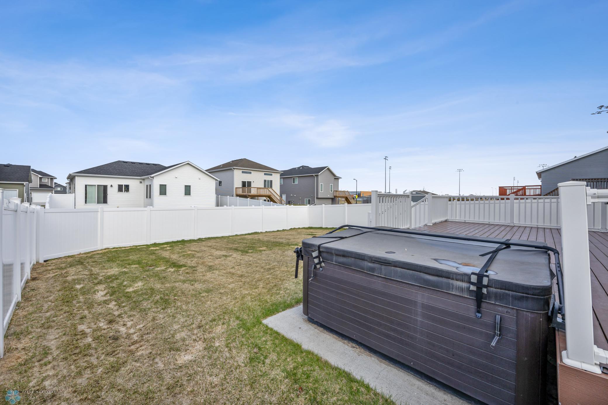 Fully fenced backyard with sprinkler, and concrete pad for included hot tub