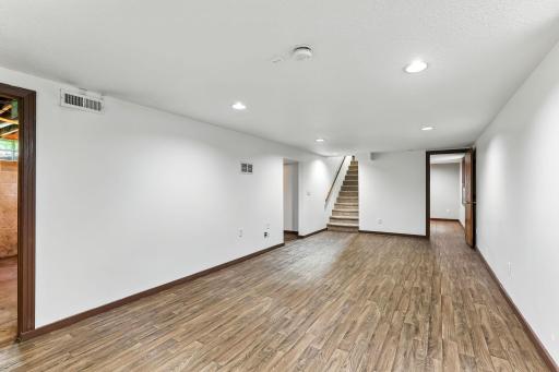 Lower-level family room showcases gorgeous flooring and a welcoming atmosphere for family living.