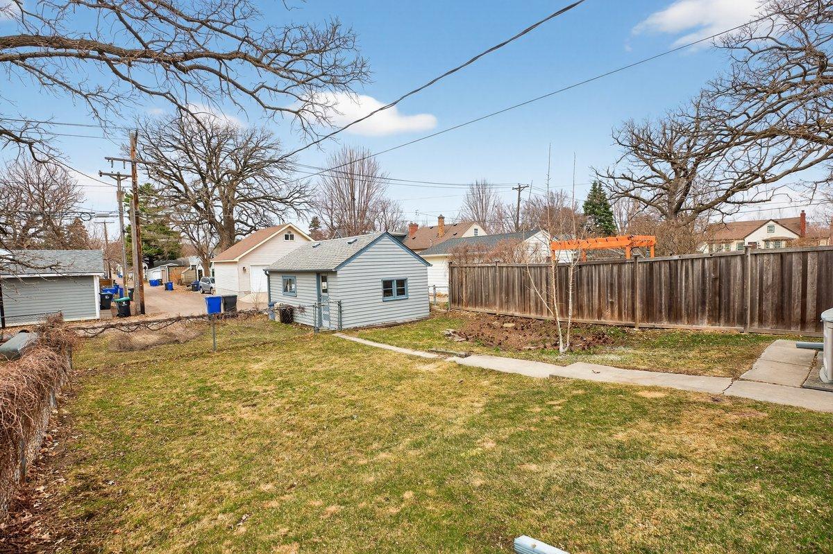 A bright, sun-filled backyard with a garden area to the right. There is plenty of room to expand the garage to a double-plus space for additional parking.