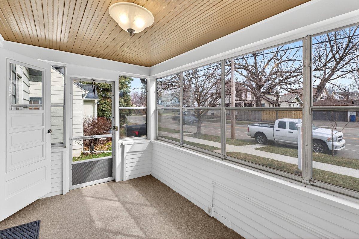 Enter the home through the sun-filled, all window three-season porch-an inviting space with the original tongue-and-groove ceiling detail and cozy carpeting. This charming sunroom adds extra living space to enjoy for much of the year in Minnesota.