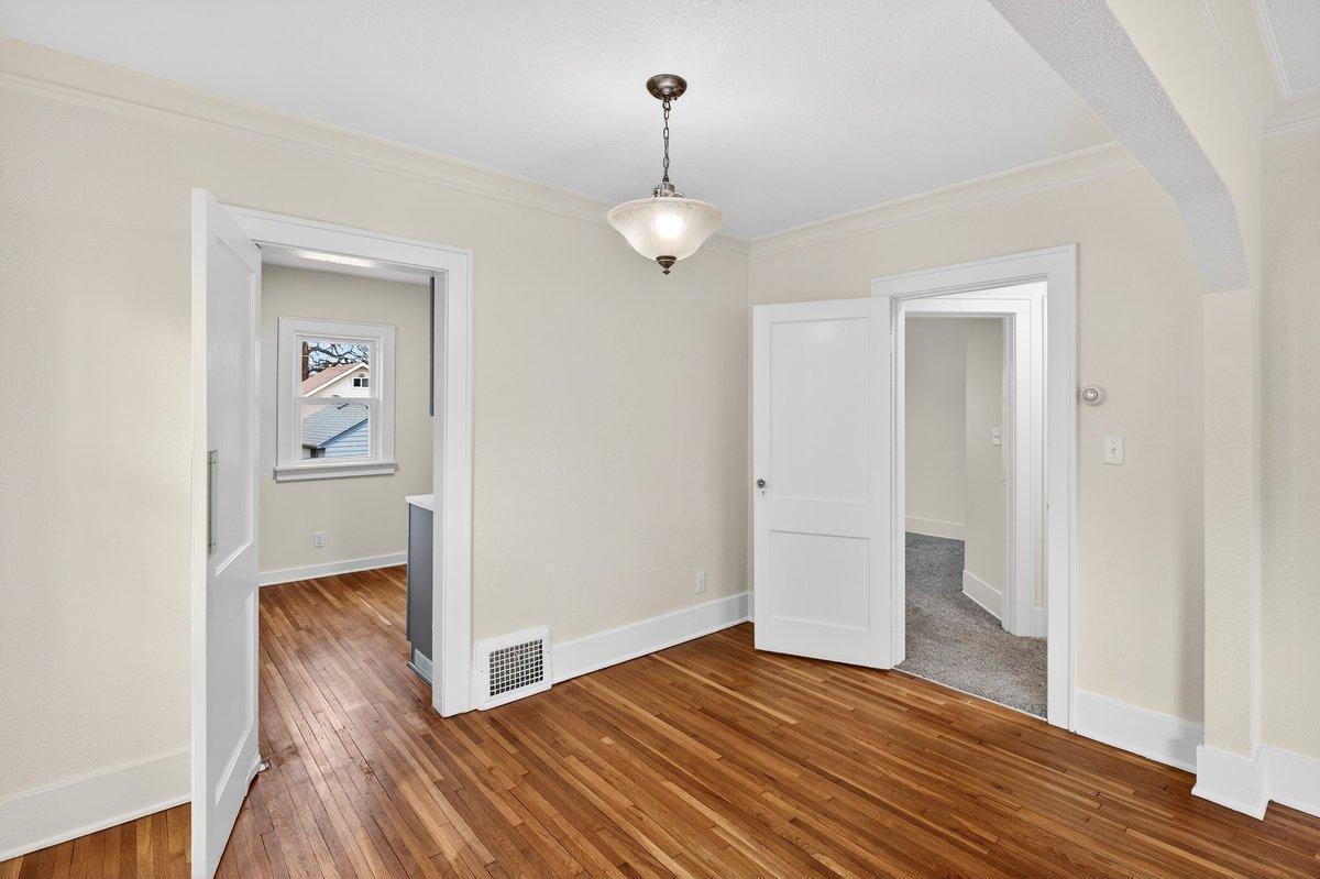 A timeless dining room featuring beautiful cove molding and a graceful archway, true to its 1920's character. A charming swing door leads to the kitchen, adding both function and nostalgic appeal.