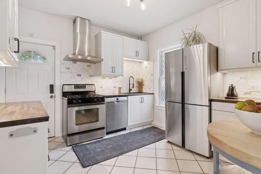 Remodeled kitchen with new cabinetry, butcher block countertops, and stainless steel appliances