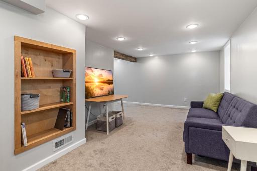 Cozy finished basement with recessed lighting, plush carpet, and built-ins