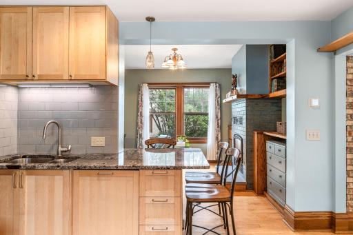 Functional kitchen layout with pendant lighting, bar seating, and open sightlines to the living area