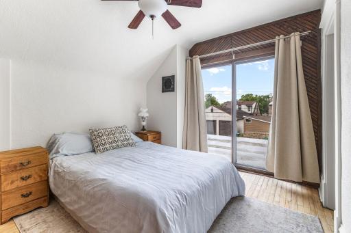 Spacious upper-level bedroom with hardwood floors and fresh natural light.