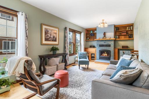 Warm and inviting living room featuring custom built-ins, hardwood floors, and a Wood burning fireplace