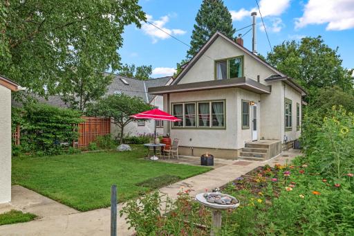 Backyard view of the home showcases the perfect blend of gardening, green space, and outdoor relaxation