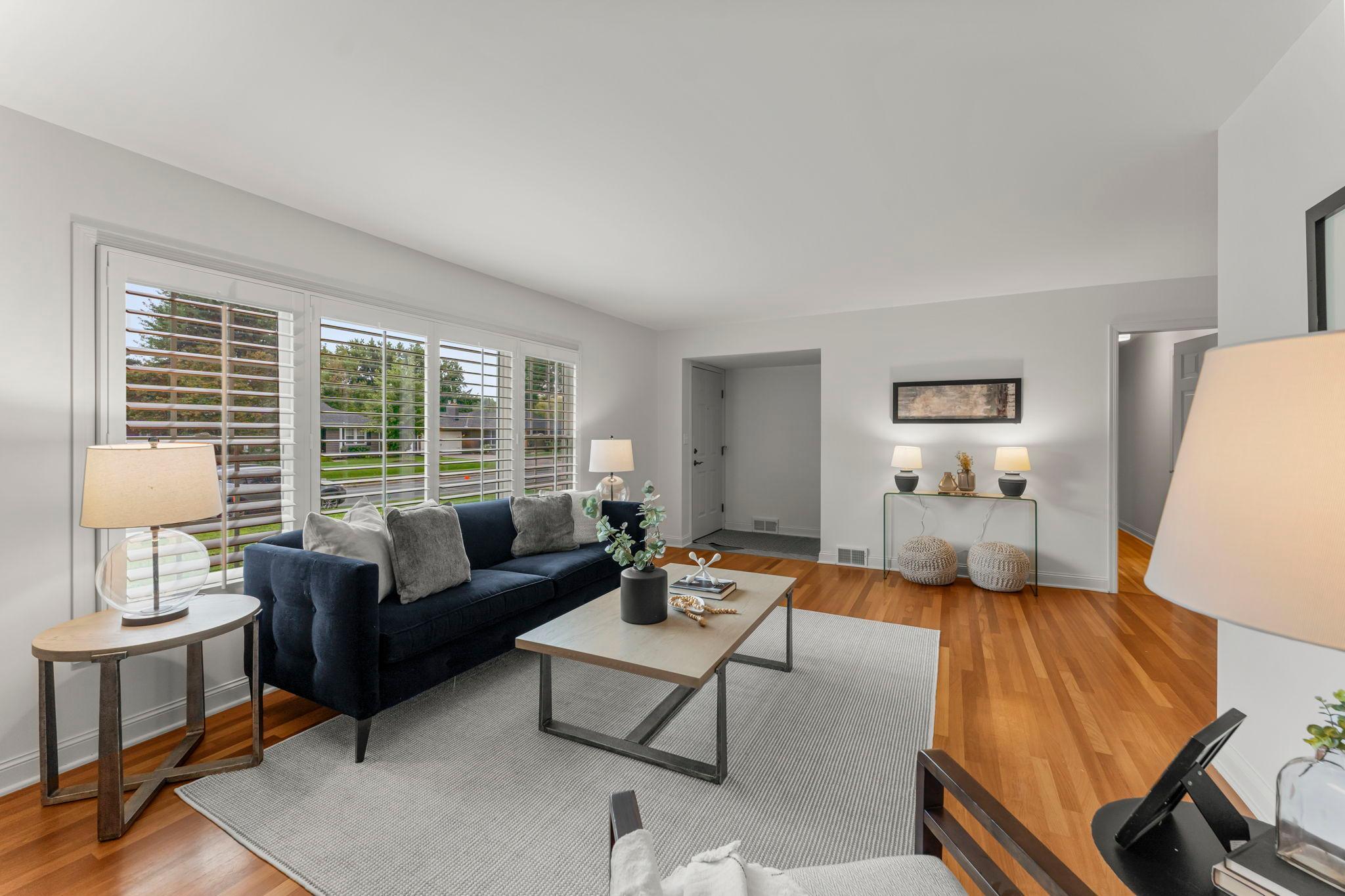 Inside, the main level is warm and inviting, with timeless wood flooring and an open-concept design that allows natural light to flow through every room.