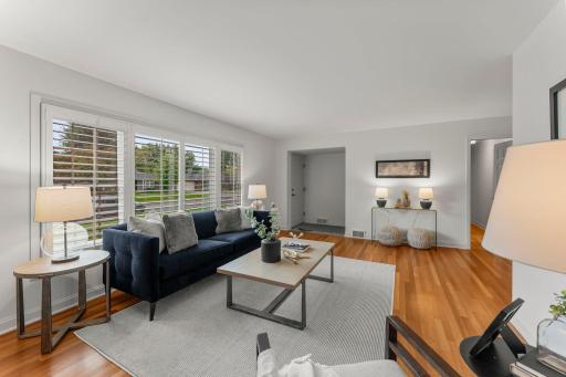Inside, the main level is warm and inviting, with timeless wood flooring and an open-concept design that allows natural light to flow through every room.