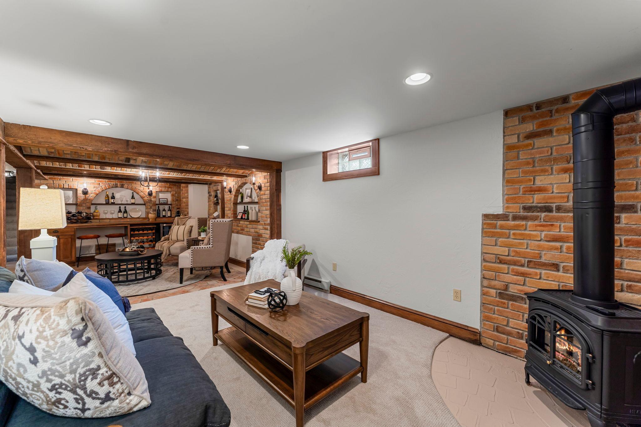 An adjoining recreation room with a freestanding gas fireplace offers the perfect spot for cozy movie nights or additional entertaining.