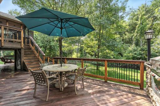 Step outside to an expansive deck with built-in stone grilling station, ideal for relaxing or entertaining.