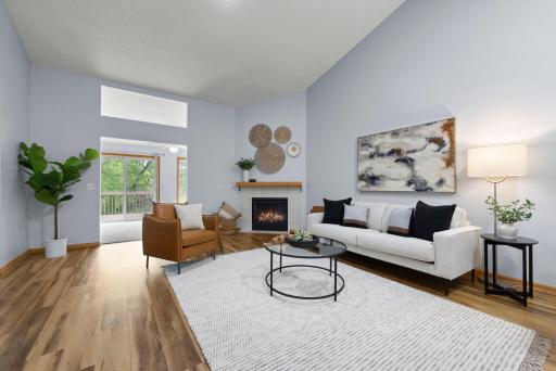The living room feels warm with the newer flooring and fireplace.