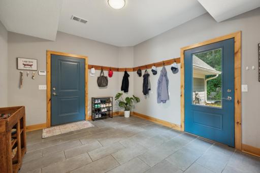 Spacious mudroom with easy access to both the garage and backyardâfeaturing durable tile flooring, ample hanging space, and a functional layout perfect for lake life and everyday living.