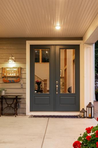 Charming front entrance with double doors and warm lighting creates an inviting first impression. Thoughtful touches and peek-through views hint at the beautiful interior beyond.