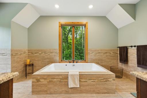 Unwind in the luxurious jetted, soaking tub, perfectly framed by serene, wooded viewsâyour own private spa retreat.