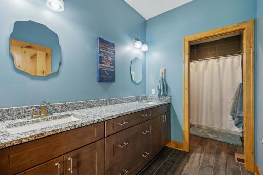 Upper level full bath featuring a granite-topped double vanity and private shower/toilet areaâperfect for busy mornings.