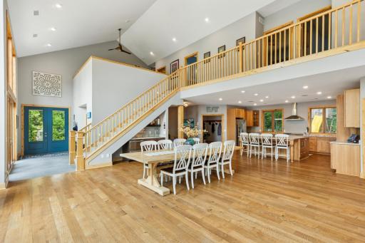 Wide open main level view highlighting the grand entry, open staircase, and upper-level balcony. A seamless flow connects the kitchen, dining, and living spacesâperfect for entertaining