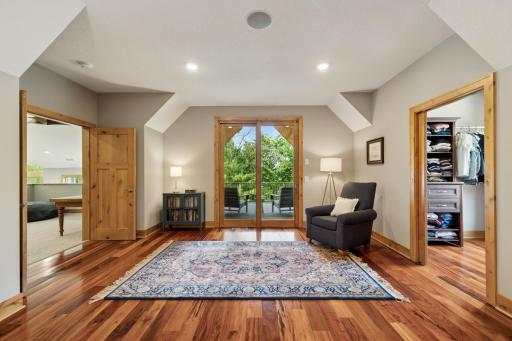 This view of the primary suite highlights a peaceful reading nook and direct access to a private, covered deckâperfect for sipping morning coffee or unwinding under the stars.