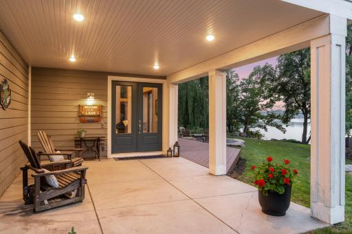 Inviting front entry with covered patio offers a cozy spot to unwind, with a maintenance-free deck leading to the beautifully landscaped yard and serene lake views beyond.