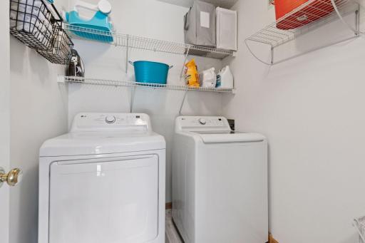 Functional and convenient upper level laundry room with shelving for storage and hanging.