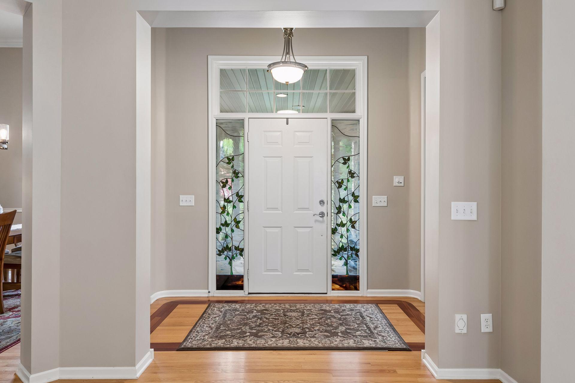 Spacious foyer to welcome guests and sidelight windows with stained glass