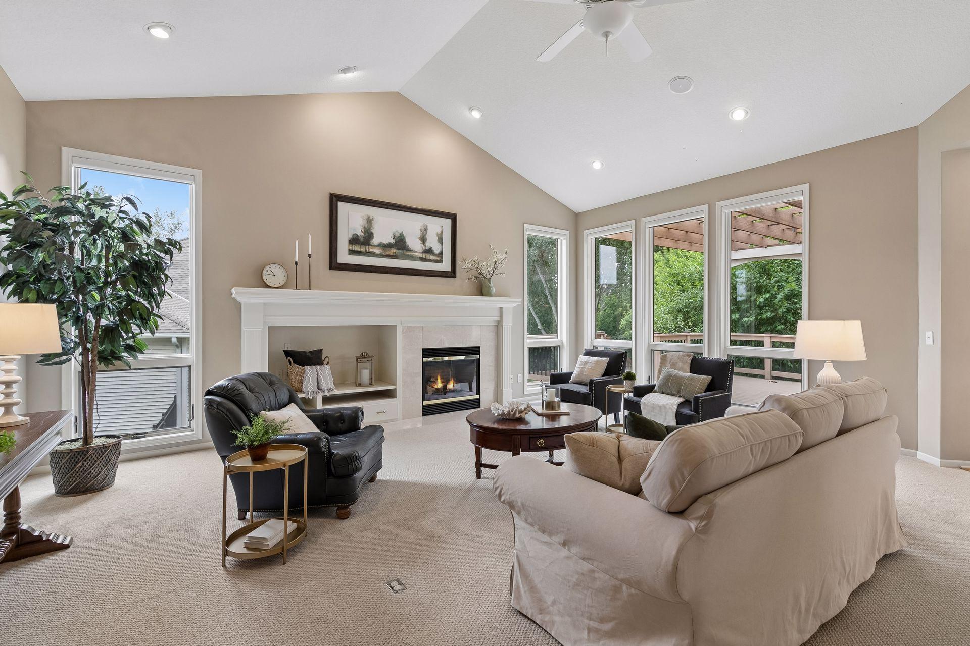 Great room with vaulted ceilings and floor to ceiling Anderson windows with auto shades